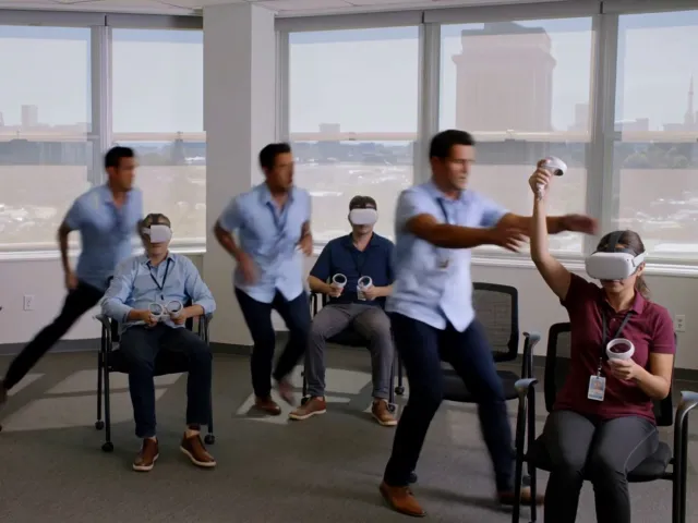A trainer rushing between learners wearing VR headsets during a group session
